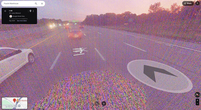 View of a highway captured on Google Maps showing cars, road markings, and navigation arrows during sunset.