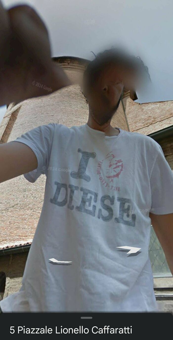 Person wearing a white Diesel t-shirt taking a distorted selfie with blurred face, showing shenanigans captured on Google Maps.