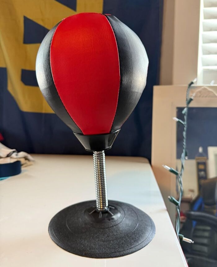 Small red and black desktop punching bag on a white desk, perfect for making the 9-to-5 less blah.