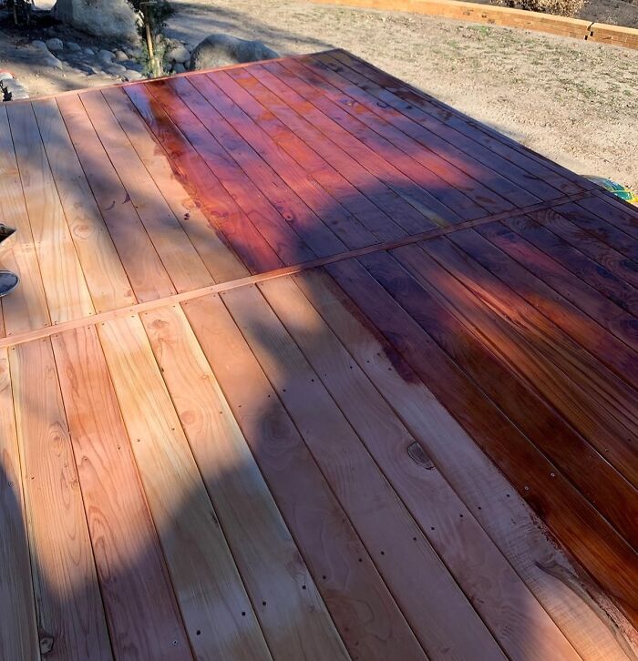 Wooden deck being stained outdoors as a sneaky way to hide the ugliest eyesores in your home.