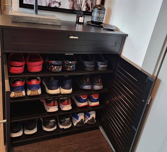 Black shoe cabinet neatly organizing sneakers to hide the ugliest eyesores in your home entryway or hallway.