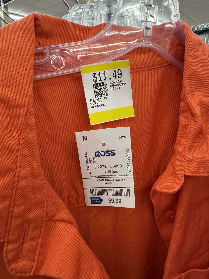 Orange dress with two conflicting price tags hanging on a hanger at a thrift store, showing thrift store finds.