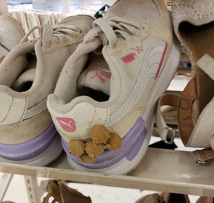 White Puma sneakers with brown clumps stuck on the heel found at a thrift store, showcasing unusual thrift store finds.
