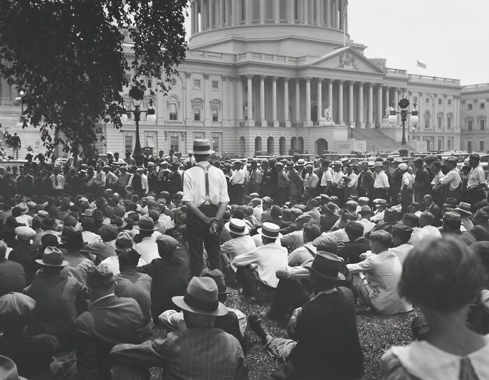 Crowd gathered in front of a historical building during a significant historical event in early 20th century.