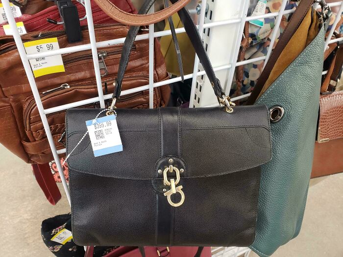 Black leather handbag priced at $399.99 on display among other bags at a thrift store with a ridiculous price tag.