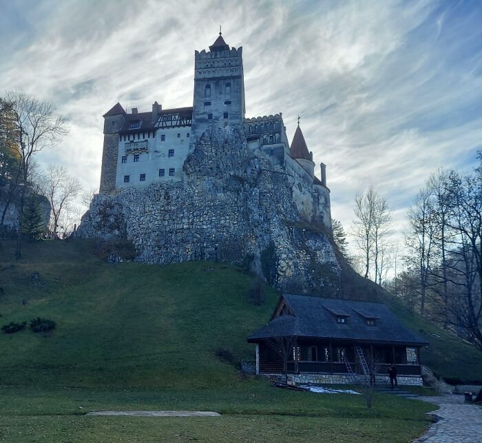 Medieval castle perched on a rocky hill with a cloudy sky, showing famous landmarks from unexpected angles.