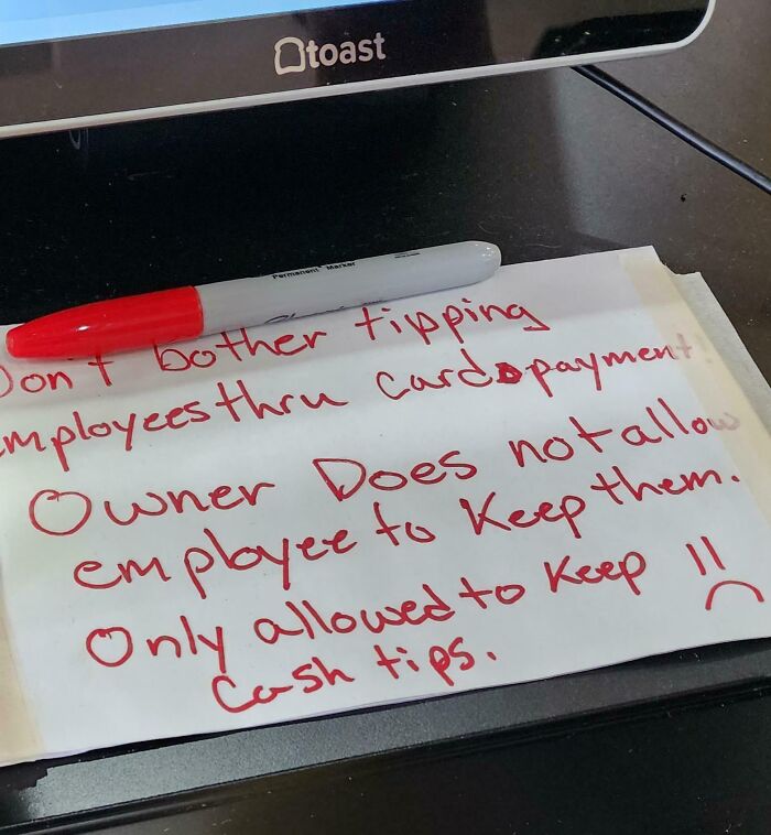 Handwritten note about tipping policies in a toxic work environment captured by an employee at a workplace.