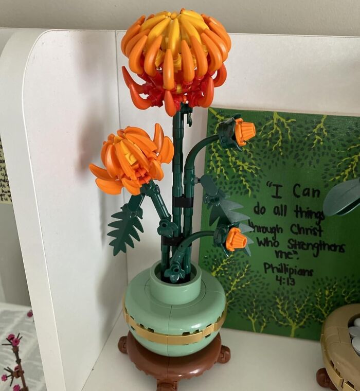 Lego flower crafting kit featuring detailed orange blooms in a green vase, showcasing top picks for creative crafting kits.