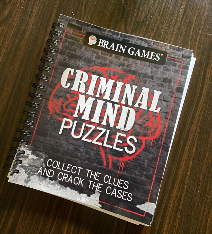 Criminal mind puzzles book on a wooden table, a popular crafting kit for stress relief and mental engagement.
