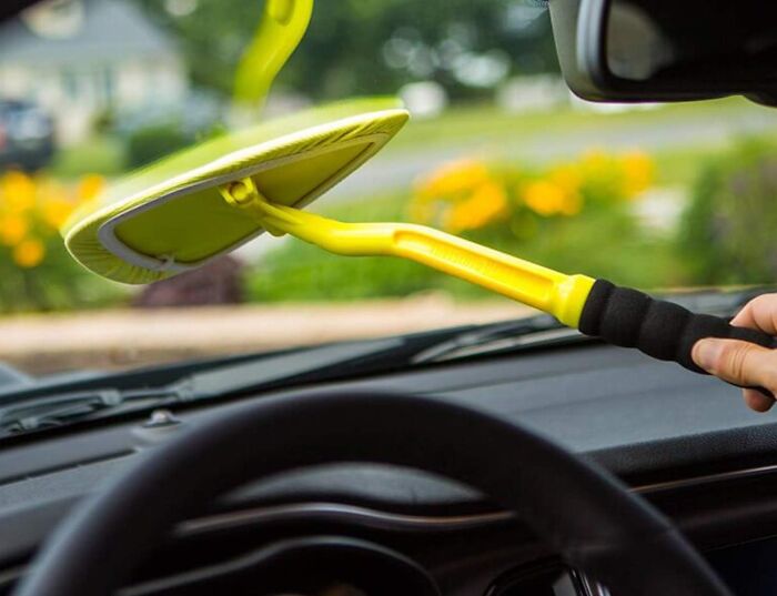 Yellow car cleaning tool with extended handle used to wipe the inside of a windshield, showcasing clever car finds.