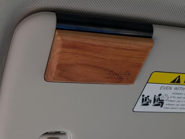 Wooden car accessory attached to a sun visor showcasing clever car finds to trick out your commute.