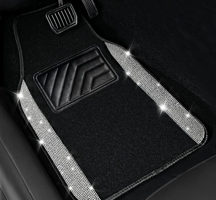 Black car floor mat with sparkling rhinestone trim placed near the pedals for a clever car accessory.