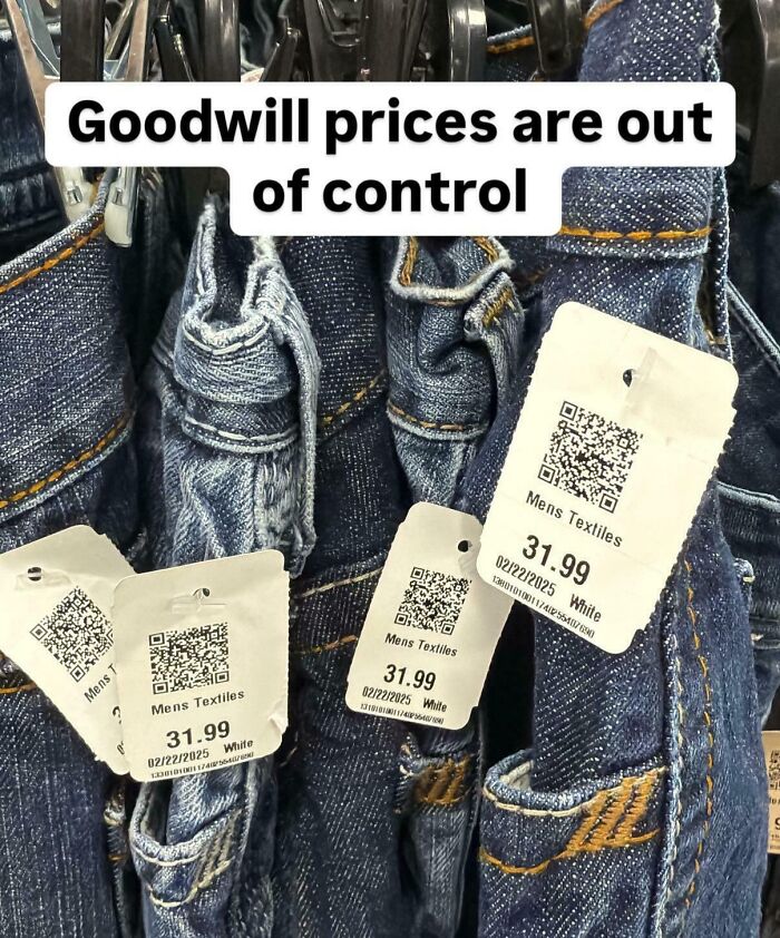 Denim jeans with thrift store price tags showing $31.99, highlighting ridiculous thrift store prices shared online.