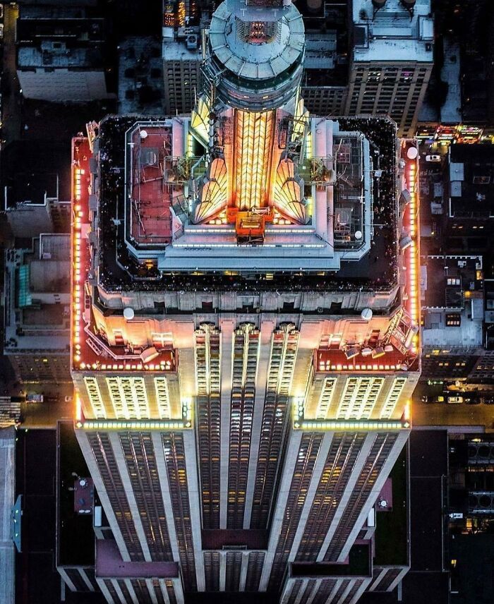 Aerial view of a famous landmark illuminated at night showcasing an unexpected angle and unique architectural details.