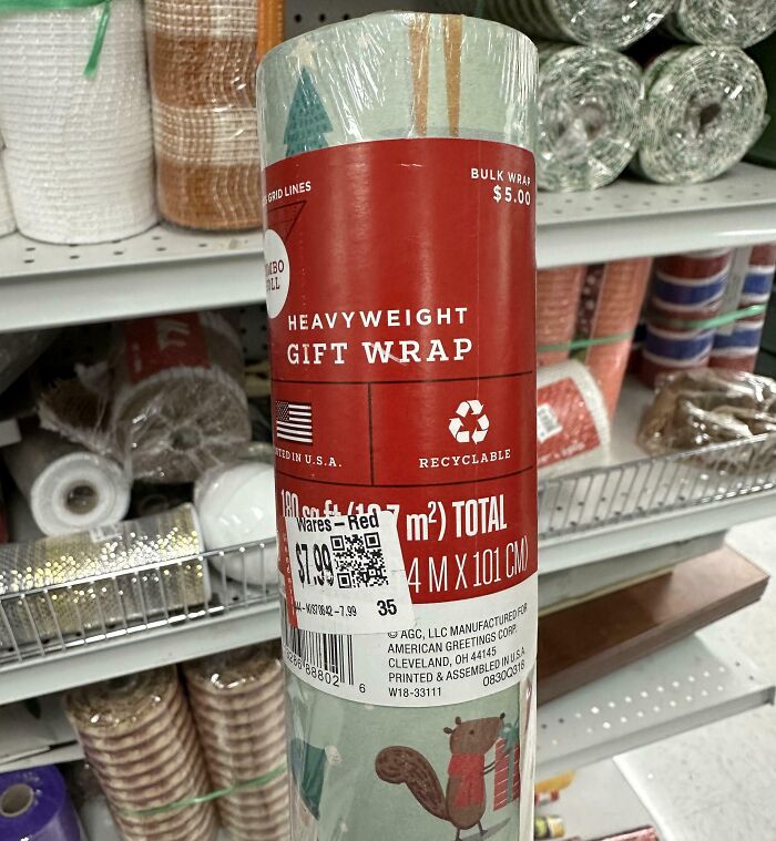 Heavyweight gift wrap with animal design seen among rolls of wrapping paper at a thrift store shelf.