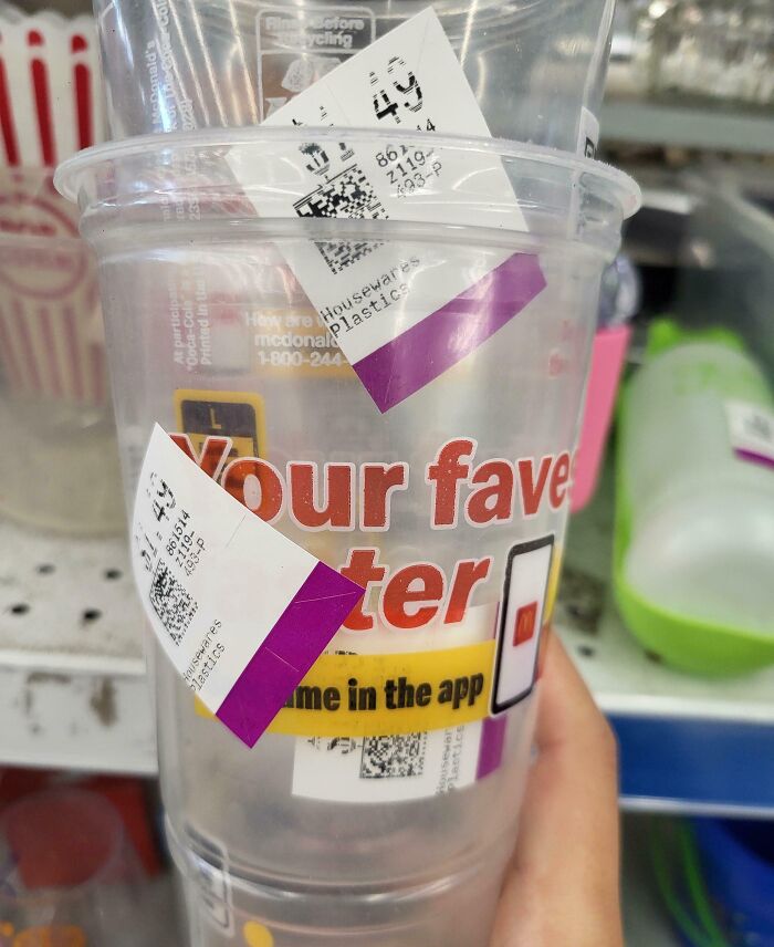 Clear plastic cup with multiple thrift store price tags stuck on it, an example of ridiculous thrift store finds.