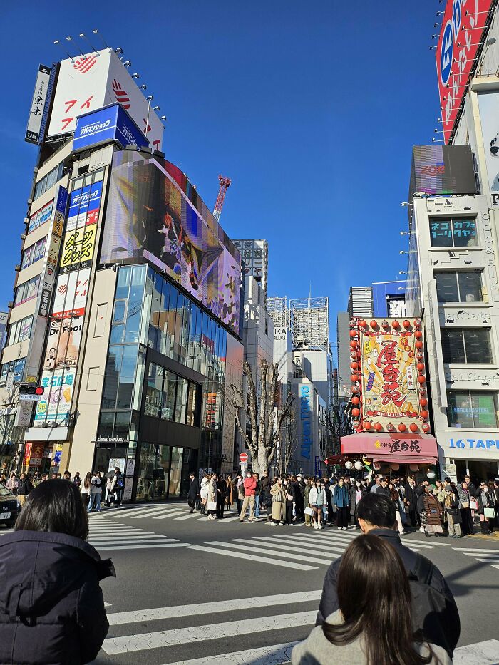 Crowded urban street scene in bright daylight, illustrating inspiring moments of people overcoming fear of flying.