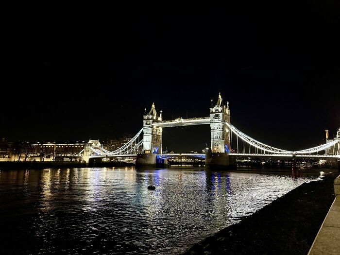 Night view of Tower Bridge in London illuminated, inspiring courage for those facing fear of flying and travel challenges.