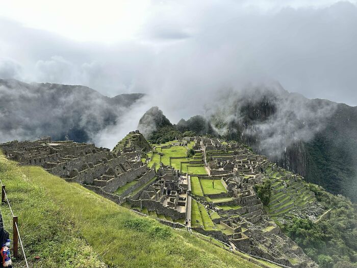 Ancient Machu Picchu ruins surrounded by mountains and clouds, inspiring travelers overcoming fear of flying to explore.