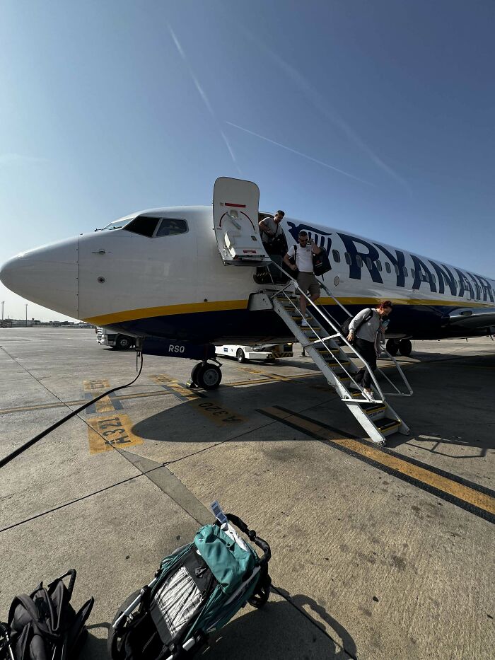 Passengers disembarking a Ryanair plane on the tarmac, illustrating moments of overcoming fear of flying.