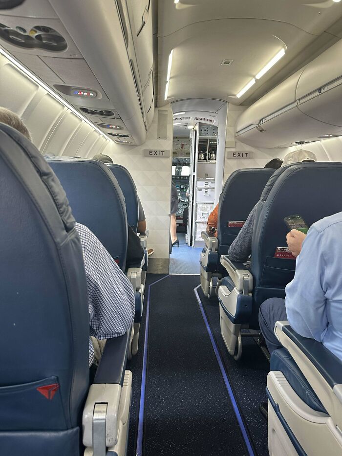 Interior view of a plane cabin with passengers seated, highlighting moments of overcoming fear of flying on board.