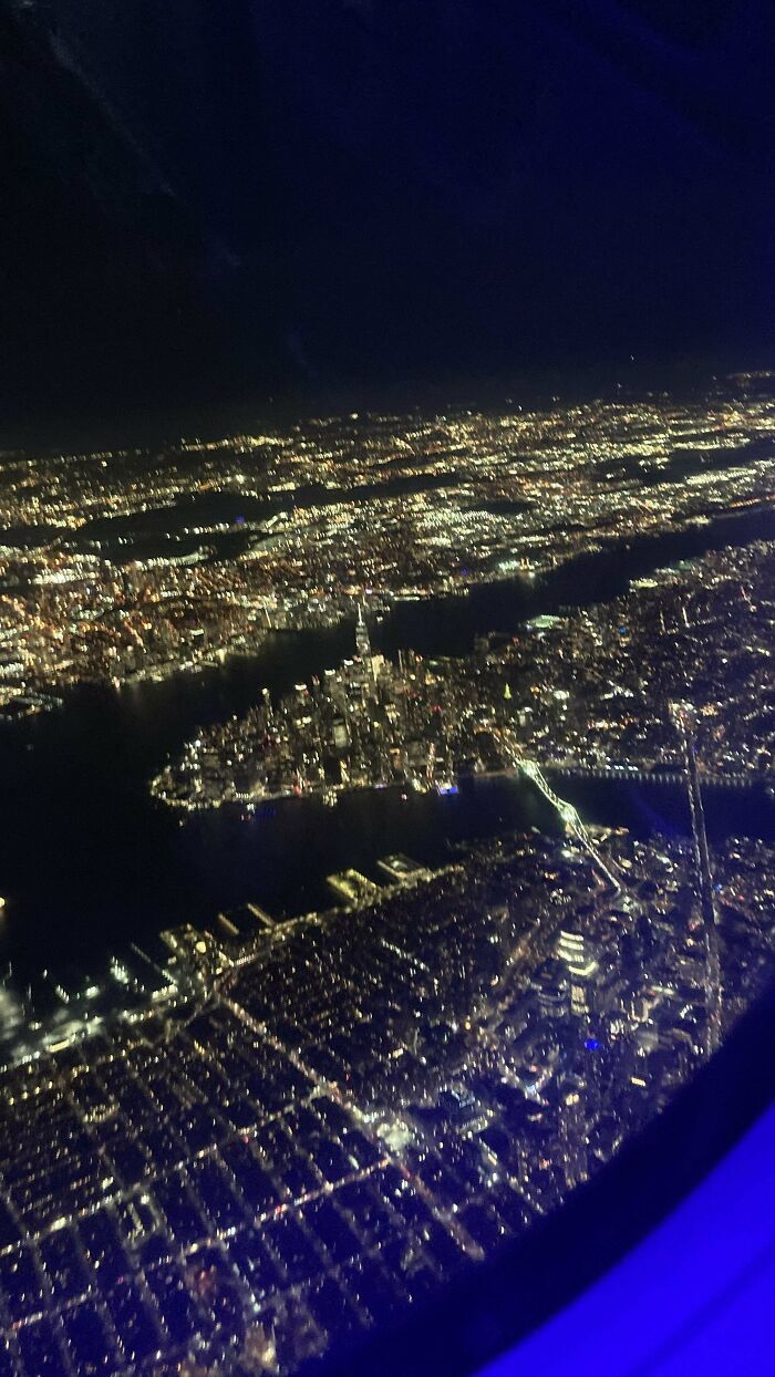 Night aerial view of a city skyline taken from a plane, capturing the inspiring experience of overcoming fear of flying.