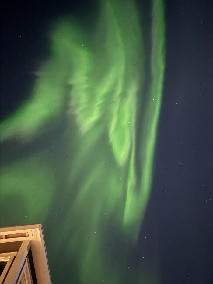 Northern lights glowing bright in the night sky inspiring people to overcome their fear of flying and board a plane.