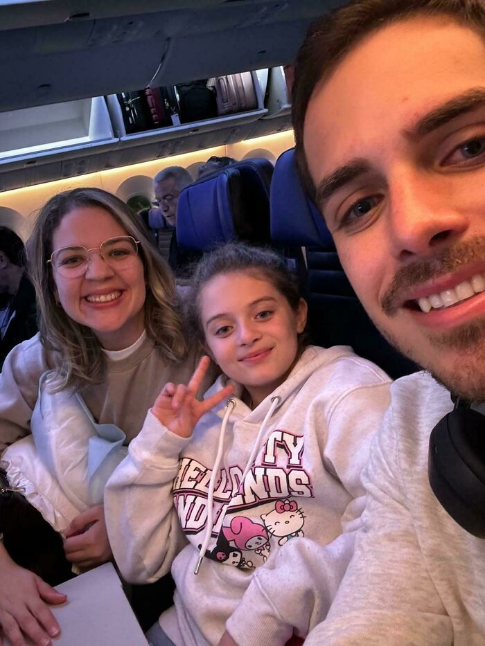 Family smiling and taking a selfie inside an airplane, showing inspiring moments of overcoming fear of flying.