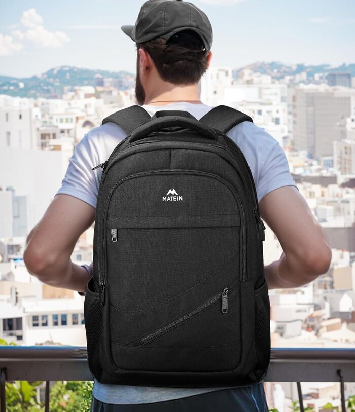 Man wearing black Matein backpack outdoors in city, showcasing early Prime Day deals on travel gear.
