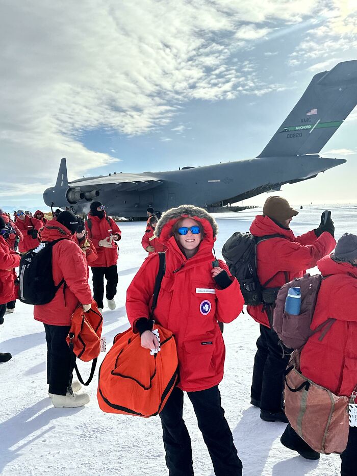 Group of people in red jackets boarding a large military plane, showcasing inspiring moments overcoming fear of flying.