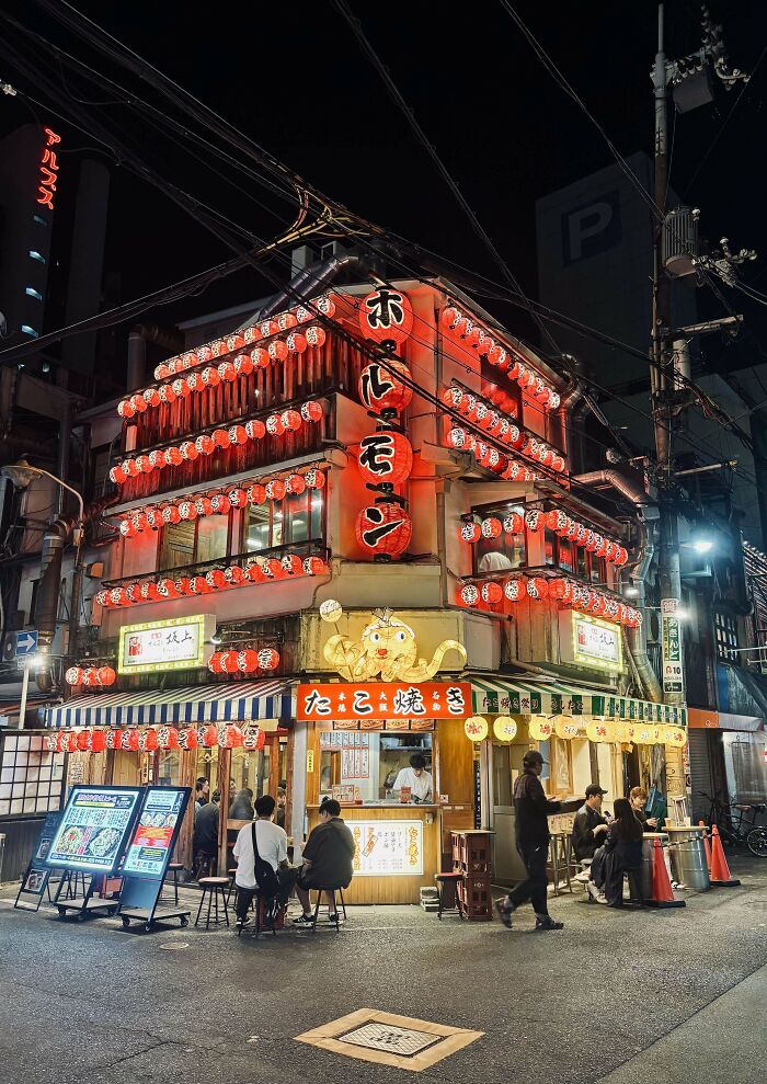 Night street scene with a lively restaurant, capturing the spirit of inspiring times people faced fear of flying.