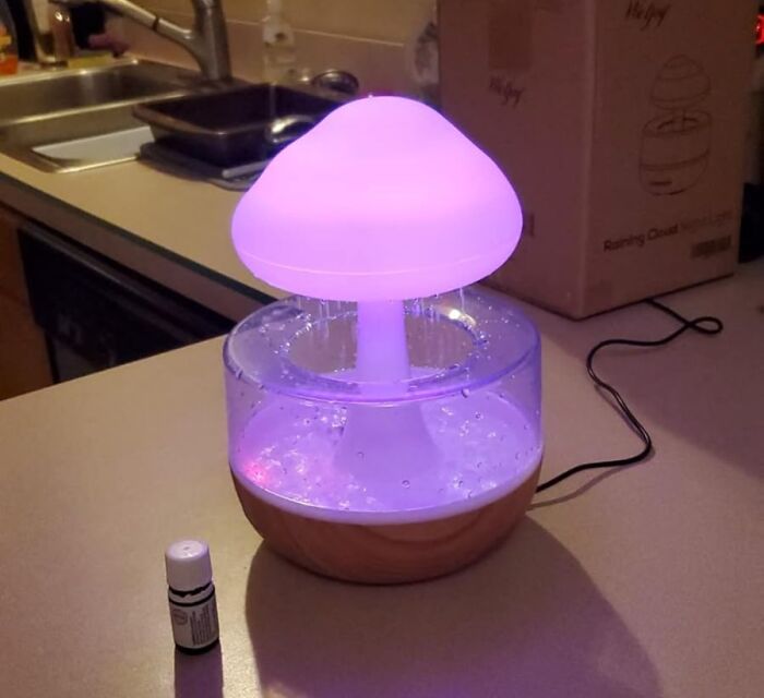 Mushroom-shaped essential oil diffuser glowing purple on kitchen counter, a quirky gem brightening your space.