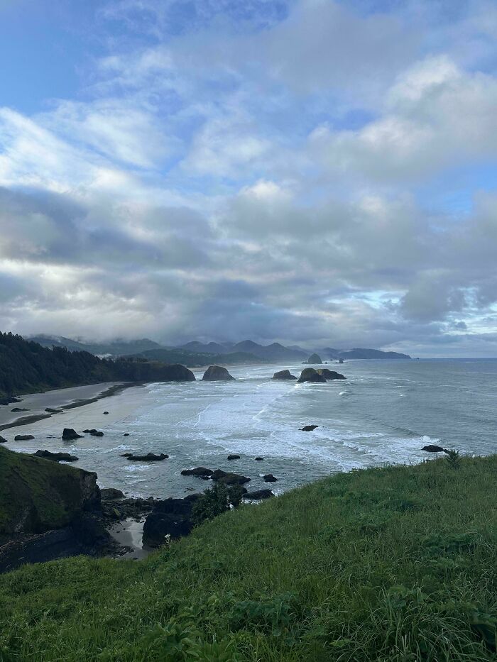 Coastal landscape with cloudy sky and rocky shoreline inspiring peaceful moments despite fear of flying.