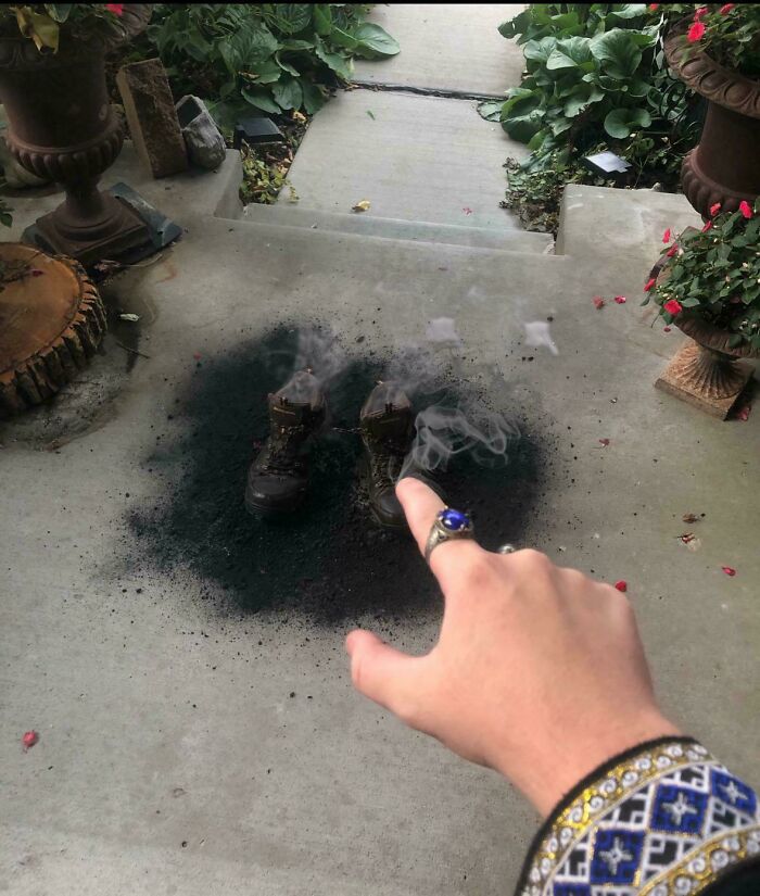 Mano señalando unas botas en el suelo con un área quemada y humo, mostrando mentirosos pillados en internet.