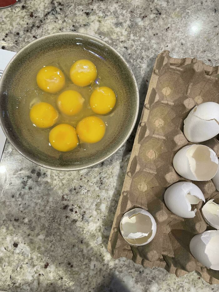 Huevos rotos sobre una mesa con cáscaras y un recipiente, representación de terribles mentirosos captados en internet.