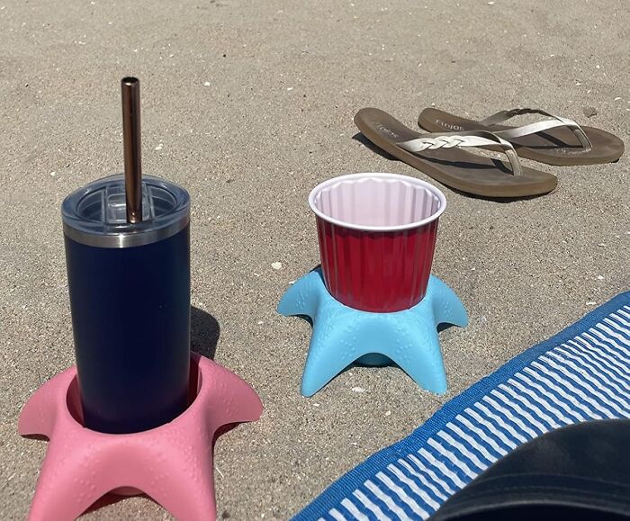 Beach scene with drinks in starfish holders on sand near flip flops and striped towel showing summer annoyances relief.