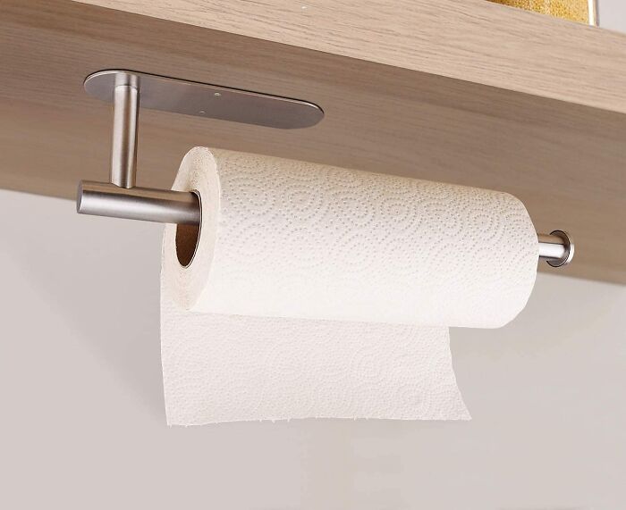 Paper towel roll mounted on a stainless steel rack under a wooden shelf, trending in the Pandaverse virtual products.