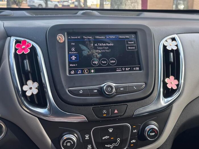 Car dashboard featuring TikTok radio on the screen and floral air vent decorations trending in virtual products.