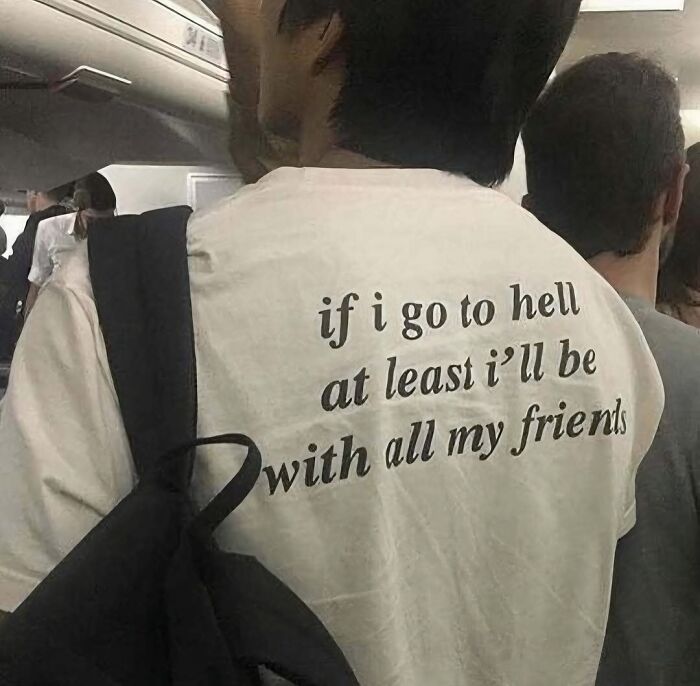 Person wearing a white shirt with a funny meme quote about going to hell with friends, relatable and humorous meme content.