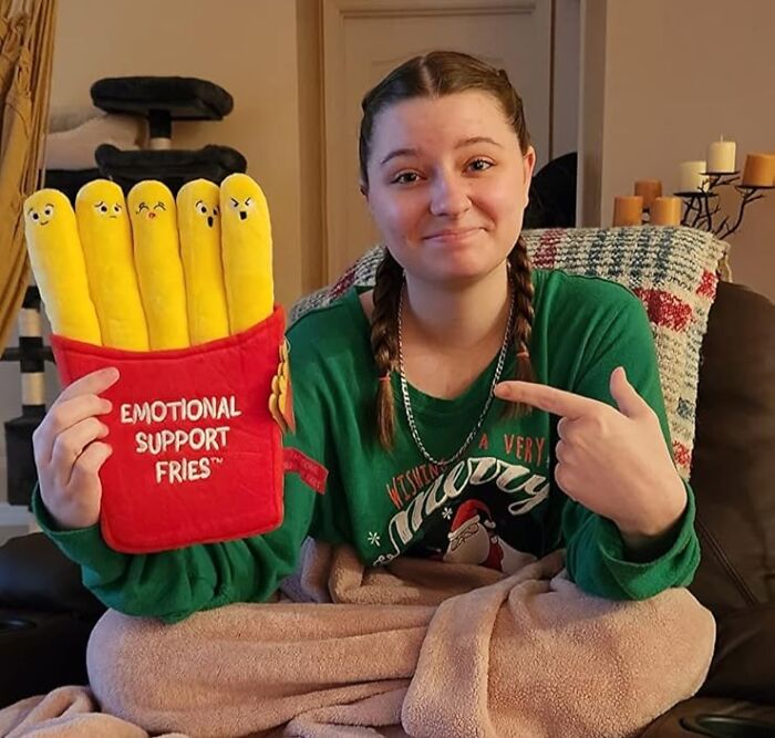 Teen girl holding emotional support fries plush toy, illustrating shopping for a 12-year-old gift ideas at home.