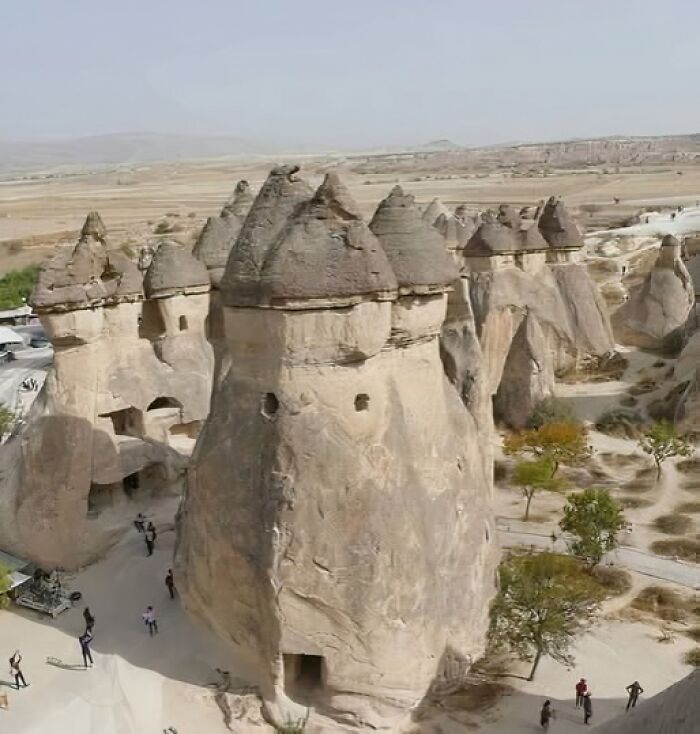 Ancient rock formations with historical dwellings in a desert landscape, showcasing archaeology world interest and exploration.