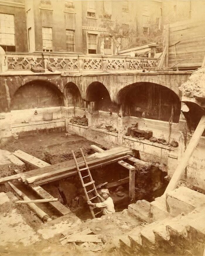 Archaeology world excavation site with a worker climbing a ladder in an ancient urban historical dig location.