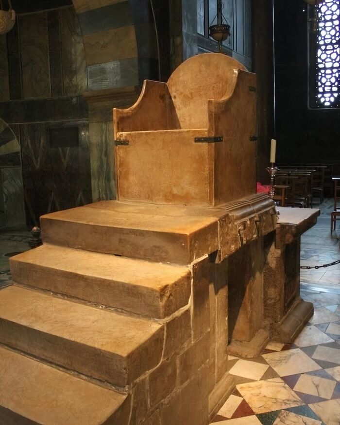 Ancient stone throne with steps inside a historical building showcasing archaeology world heritage and artifacts.