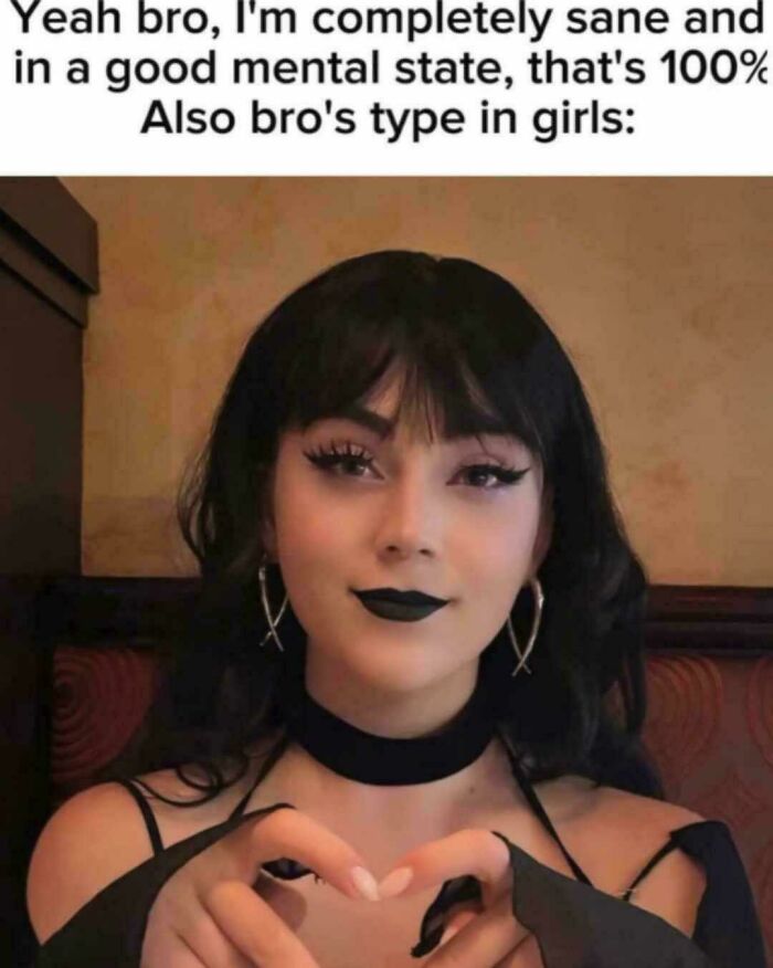 Young woman with black lipstick and earrings making a heart shape with fingers in a meme about explaining the joke.