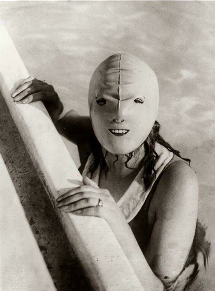 Vintage black and white photo of a woman in an old-fashioned swimming mask, a ridiculous pic from the past.