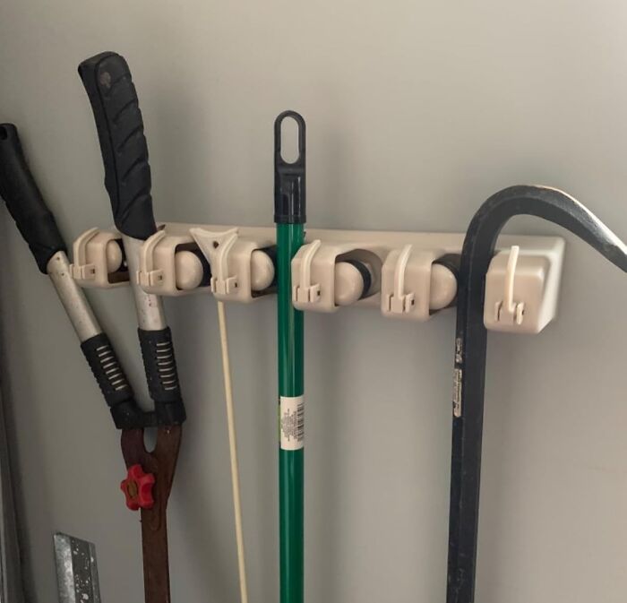 Wall-mounted tool organizer holding garden tools and a crowbar, one of the popular Amazon wishlist finds.