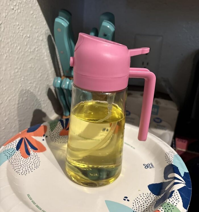 Clear oil dispenser with a pink lid and handle, one of the popular finds on Amazon wishlists and trending now.