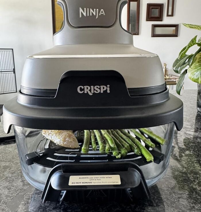 Ninja CRISPi air fryer oven cooking seasoned asparagus on a kitchen countertop, a popular Amazon wishlist find.
