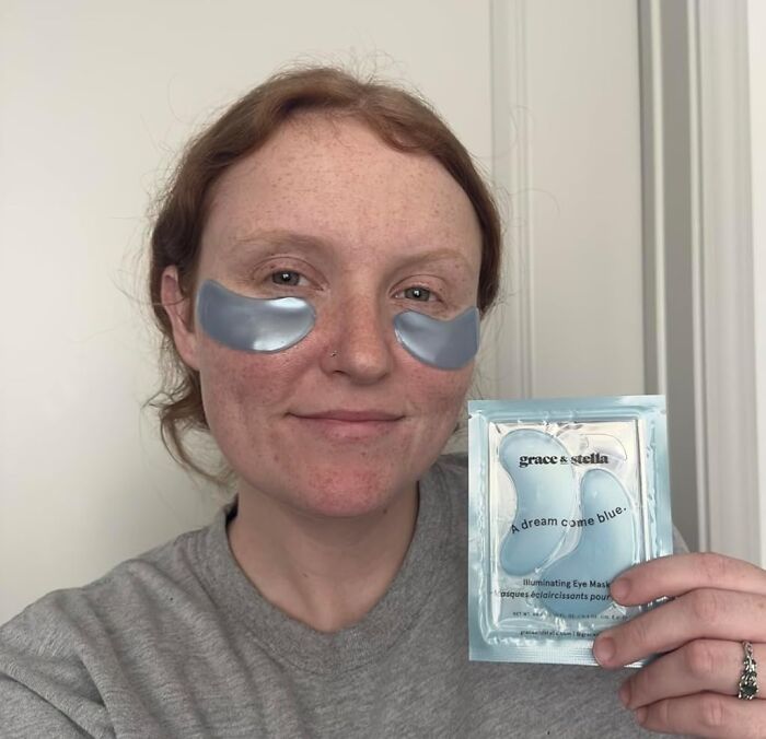 Woman wearing under-eye patches and holding skincare product, one of the popular finds on Amazon wishlists.
