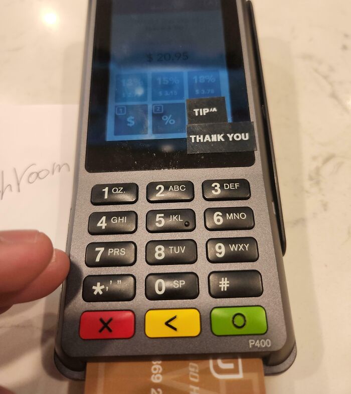 Payment terminal keypad with small receipts labeled tip and thank you highlighting ridiculous tipping culture issues.